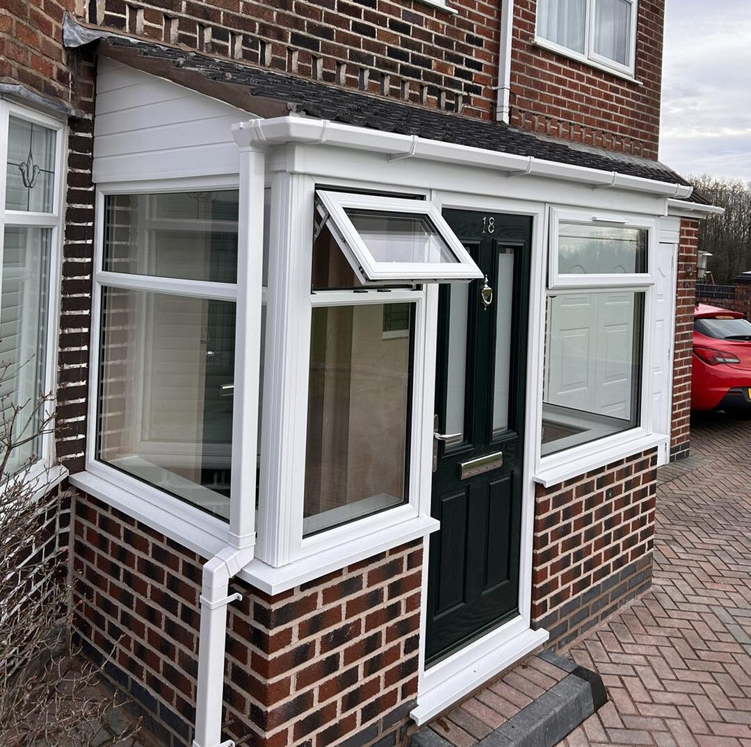 A brick house featuring a white door and a green door, showcasing a charming and inviting exterior.