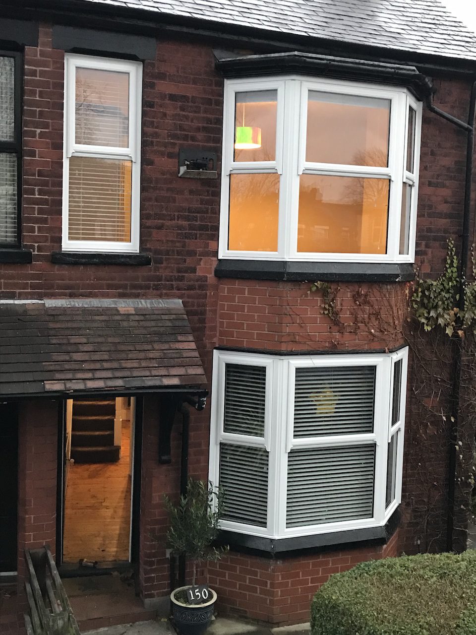 a nice whote sliding sash window on a bricked dark red wall