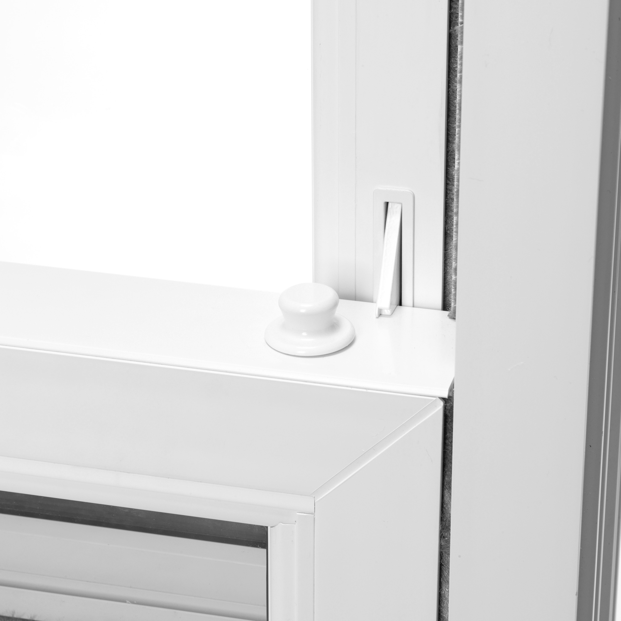 A zoomed part of a white window that shows that sliding feature of a sliding sash window.