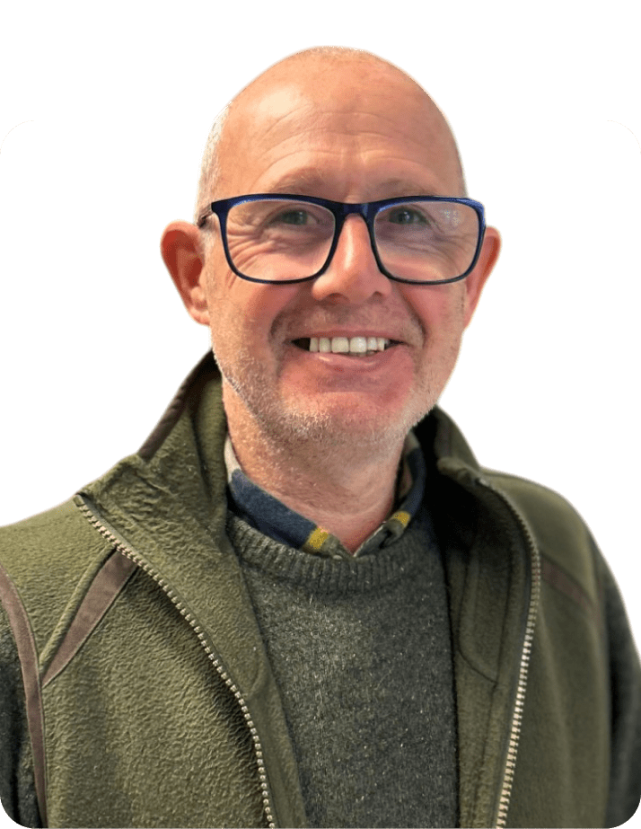 A man wearing a blue-framed glasses and green shirt and jacket, named Phil, the sales person of quadrant windows