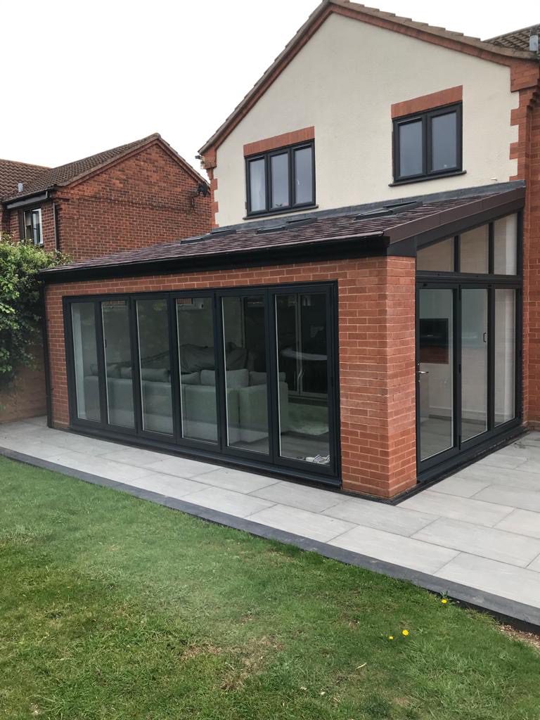 A spacious extension featuring a prominent glass roof, allowing ample natural light to illuminate the interior.